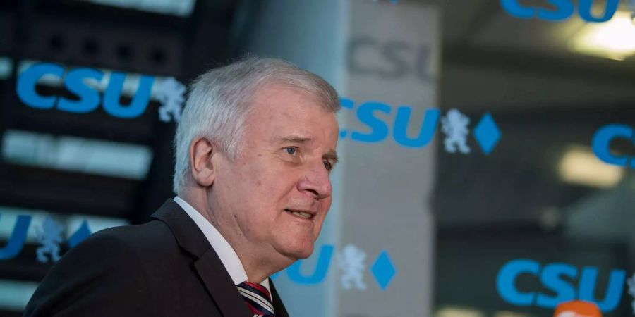 Horst Seehofer (CSU), Bundesminister für Inneres, Heimat und Bau, geht vor Beginn der CSU-Vorstandssitzung an einer Wand mit dem Parteilogo entlang.