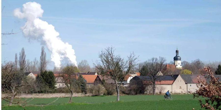 Die Kühltürme des Braunkohlekraftwerks Lippendorf (D) dampfen hinter dem Dorf Pödelwitz (D) südlich von Leipzig (D).