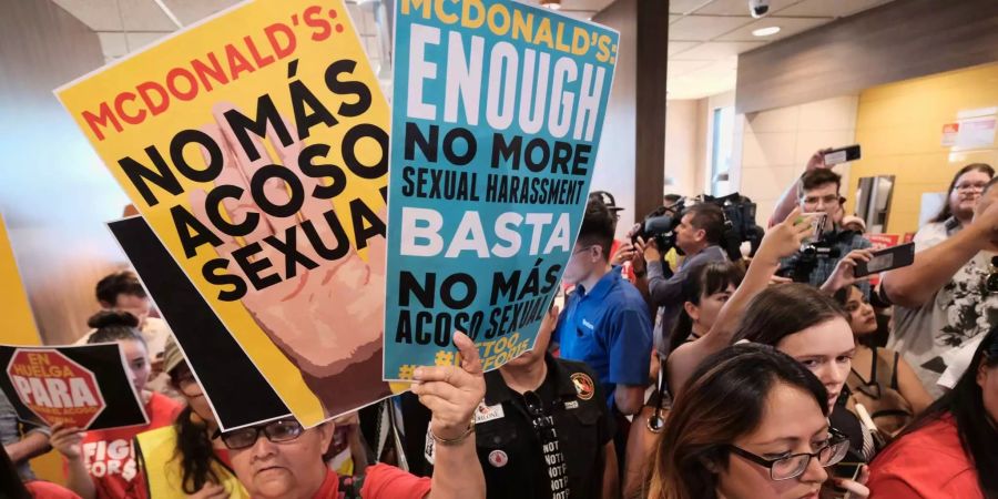 McDonald's Mitarbeiter drängen sich mit Protestschildern in einem McDonalds-Restaurant im Süden von Los Angeles.