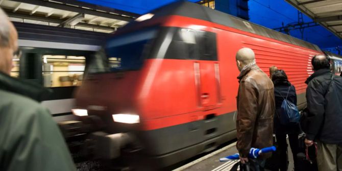Reisende warten auf einen Zug nach Lausanne im Bahnhof Cornavin in Genf.