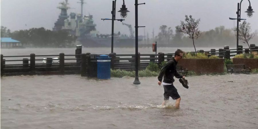 Ein Mann überquert eine überflutete Strasse in Wilmington.