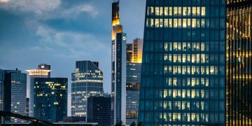 Nach Feierabend sind die Büros der Zentrale der Europäischen Zentralbank (r) noch immer beleuchtet.