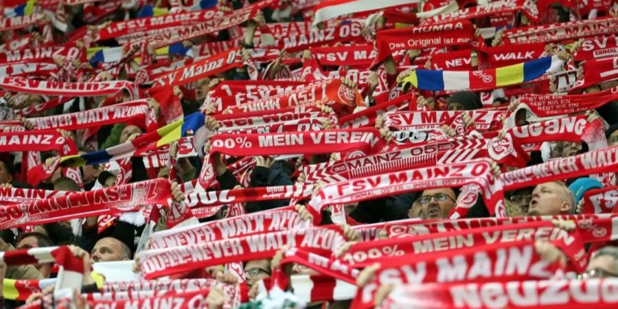 Fans des 1. FSV Mainz 05 halten ihre Schals in die Luft.