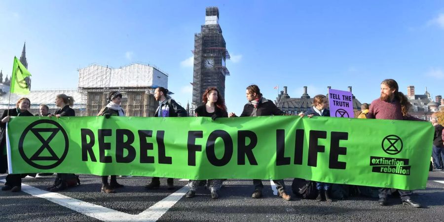 Demonstranten auf der Westminder Bridge halten ein Banner mit der Aufschrift "Rebel for life".