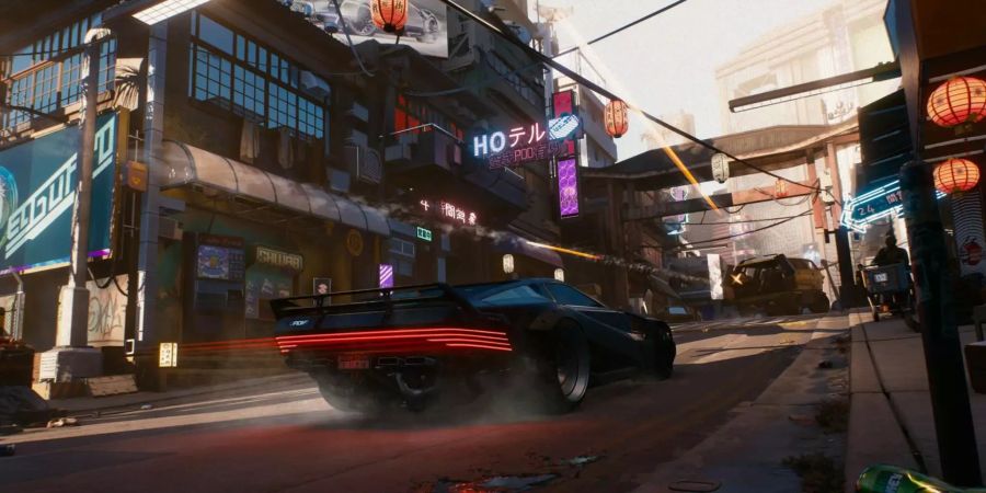 Cyberpunk 2077: Ein schwarzes Auto fährt durch die Strassen von Night City.