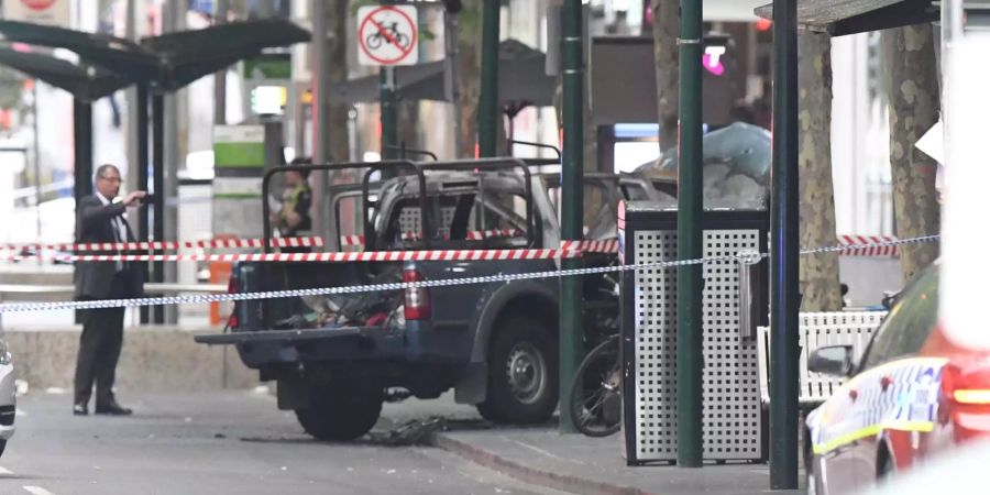 Das ausgebrannte Fahrzeug steht nach einem mutmasslichen Terrorangriff in der Innenstadt von Melbourne (AUS).