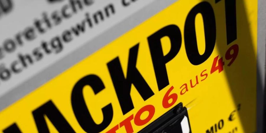 Ein Schild vor einer Lotto-Annahmestelle weist auf den aktuellen Jackpot von 34 Millionen Euro hin. Foto: Philipp von Ditfurth/dpa