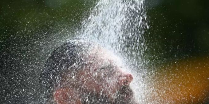 Ein Mann kühlt sich im Freibad unter einer Dusche ab. Foto: Patrick Seeger/dpa Ein Mann kühlt sich im Freibad unter einer Dusche ab. Foto: Patrick Seeger/dpa