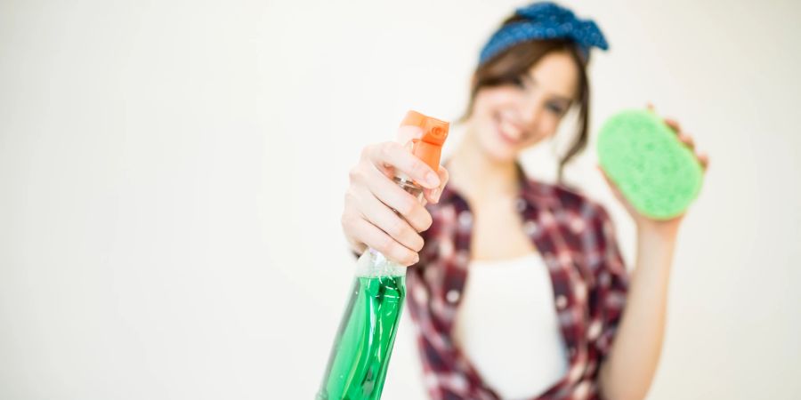 Frau mit Sprühflasche und Schwamm