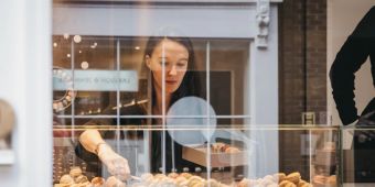 frau in bäckerei packt macarons zusammen