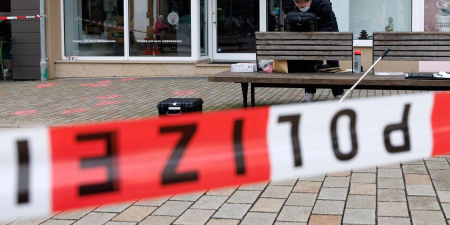 Eine Polizeibeamtin der Kriminaltechnik steht an einem abgesperrten Tatort.