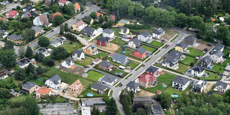 Grüner Rasen und Einfamilienhäuser bestimmen das Bild einer Stadtrandsiedlung.