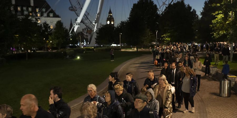 Menschen warten in einer Schlange, um der verstorbenen Königin Elizabeth II. während der Aufbahrung in London die letzte Ehre zu erweisen. Foto: Felipe Dana/AP/dpa