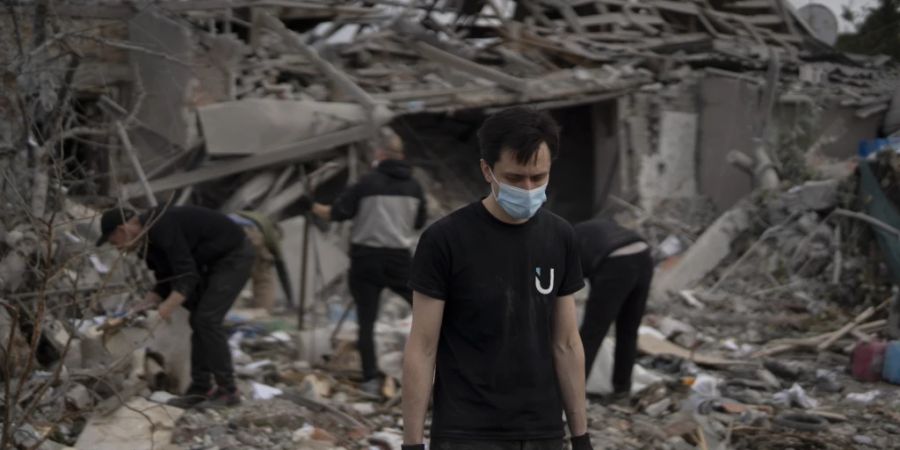 dpatopbilder - Freiwillige Helfer arbeiten an der Beseitigung von Trümmern, nachdem mehrere Häuser nach einem Angriff auf ein Wohngebiet in Saporischschja zerstört wurden. Foto: Leo Correa/AP/dpa