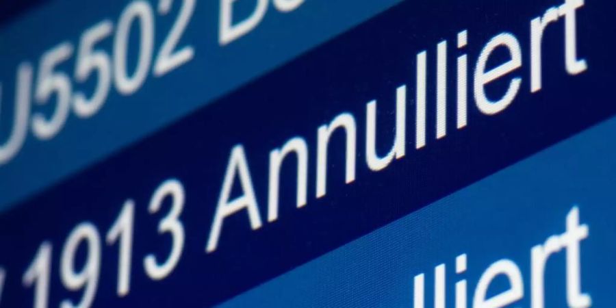 "Annulliert" steht auf einer Anzeige im Flughafen Düsseldorf für zwei Flüge der Fluggesellschaft Germanwings. Foto: Marcel Kusch/dpa