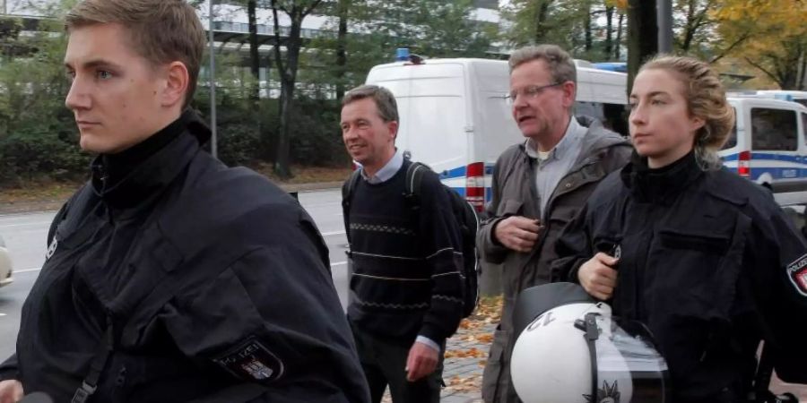 AfD-Mitbegründer Bernd Lucke (2.v.l.) verlässt nach seiner durch massive Proteste gestörten Antrittsvorlesung von Polizisten geschützt den Campus der Universität Hamburg. Foto: Markus Scholz/dpa