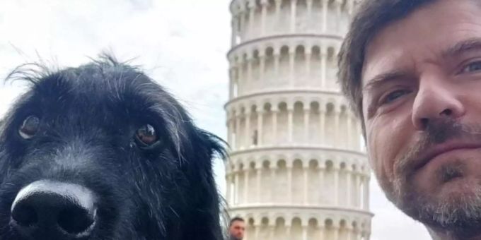 Kriss Rudolph mit seinem Labrador-Mischling Mompa vor dem Schiefen Turm in Pisa - der Hund verträgt das Fliegen gut. Foto: Kriss Rudolph/dpa-tmn
