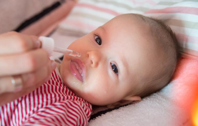 Nasentropfen sollten Eltern ihren Kindern am besten dann verabreichen, wenn diese auf der Seite liegen. Baby Nasentropfen Hand Speichel Bett