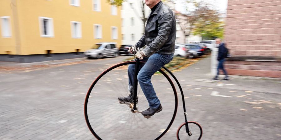 Tobias Krieger fährt mit einem Hochrad eine Strasse entlang. Der Karlsruher ist mit dem Hochrad unterwegs - wie die Menschen am Ende des 19. Jahrhunderts. Heute zählt er zu wenigen, die das noch können.
