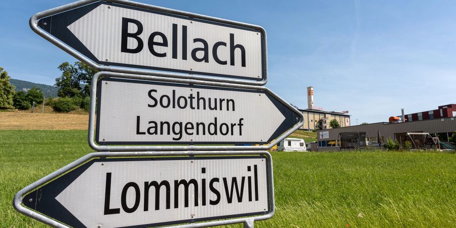 Ein Strassenwegweiser Richtung Bellach, Solothurn, Langendorf und Lommiswil an der Lommiswilstrassse in Langendorf. Hinten rechts das Gewerbegebiet von Langendorf.