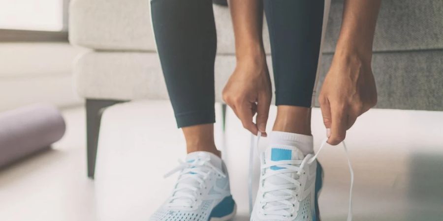 Frau zieht Turnschuhe an