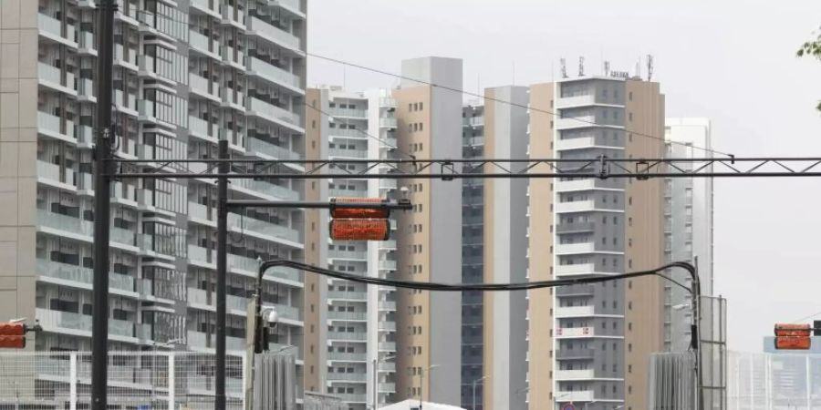 Sicherheitskräfte stehen vor dem Olympischen Dorf in Tokio. Foto: ---/Kyodo/dpa