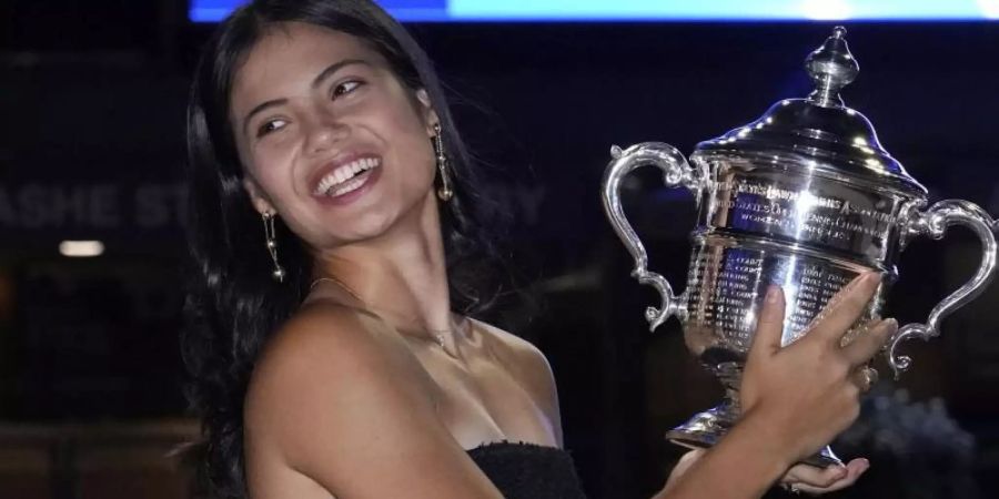 Die Britin Emma Raducanu posiert vor dem Arthur-Ashe-Stadion mit der Meisterschaftstrophäe. Foto: Elise Amendola/AP/dpa