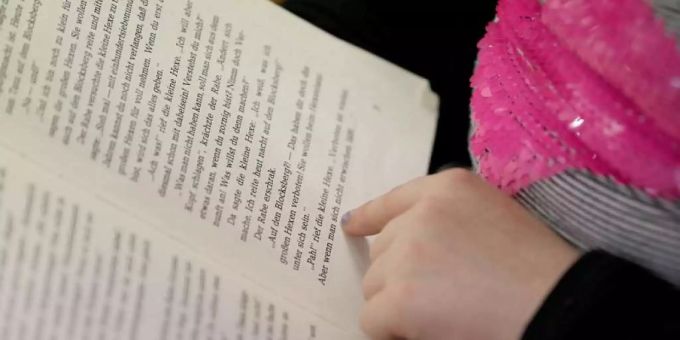 Ein Kind liest in einem Buch. (Symbolbild) lesen