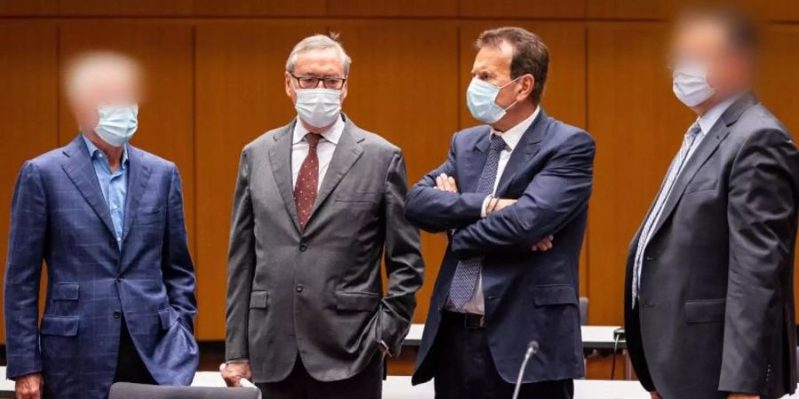 Horst Neumann (2.v.l) und Karlheinz Blessing (2.v.r), ehemalige VW-Konzernpersonalvorstände, stehen mit zwei weiteren Angeklagten kurz vor Prozessauftakt in der Stadthalle Braunschweig zusammen. (Archivbild). Foto: Moritz Frankenberg/dpa