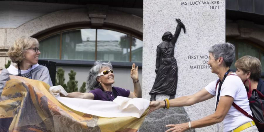 Romy Biner-Hauser, Gemeindepräsidentin, Rita Christen, Präsidentin des Schweizer Bergführerverbands SBV und Françoise Jaquet, Präsidentin des SAC,  enthüllen im Beisein von Bundesrätin Viola Amherd die Skulptur zu Ehren von Lucy Walker. (von links)