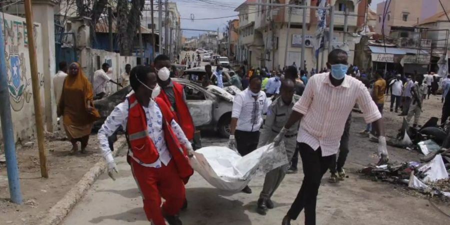 Medizinische Helfer transportieren nach dem Selbstmordattentat ein Todesopfer ab. Foto: Farah Abdi Warsameh/AP/dpa