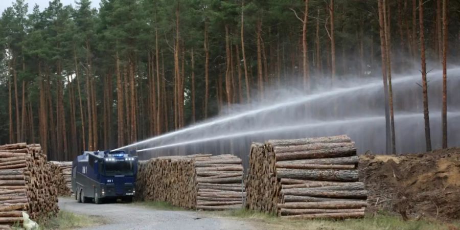 Ein Wasserwerfer spritzt Wasser in den Wald