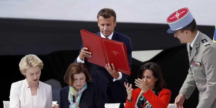 Die Verteidigungsministerinnen von Deutschland, Frankreich und Spanien (v.l.), Ursula von der Leyen, Florence Parly und Margarita Robles, tauschen bei der Vertragsunterzeichnung Dokumente aus. Foto: Yoan Valat/POOL EPA/AP