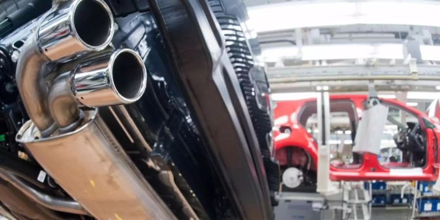 Ein Auspuffrohr von einem VW Golf 7 mit TDI Dieselmotor im Licht einer Fertigungsstrecke. Foto: Julian Stratenschulte