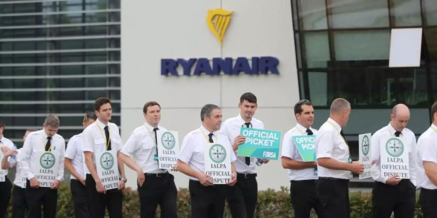 Piloten der Fluggesellschaft Ryanair streiken und stehen mit Schildern vor dem Firmensitz des Unternehmens. Die in Irland stationierten Piloten der Billigfluggesellschaft Ryanair drohen mit Streik. Foto: Niall Carson/PA Wire/dpa