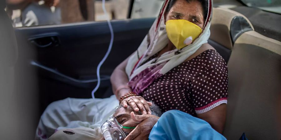 Ein Patient atmet mit Hilfe von Sauerstoff in einem Auto in Neu-Delhi. In Indien hat es den fünften Tag in Folge einen weltweiten Rekord bei den Corona-Neuinfektionen gegeben. Foto: Altaf Qadri/AP/dpa