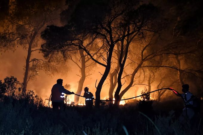 dpatopbilder - 19.05.2021, Griechenland, Schinos: Feuerwehrleute versuchen, die Flammen während eines Waldbrandes in der Nähe von Korinth zu löschen. Wald- und Buschbrände in Griechenland