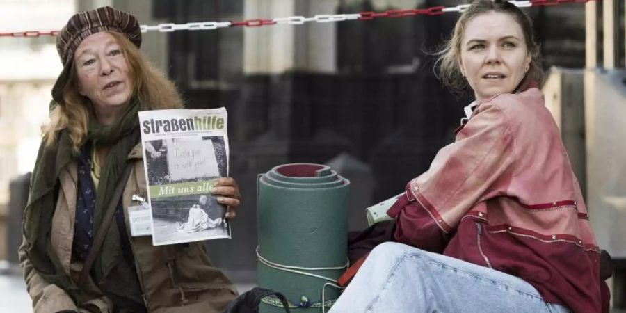 Monika Keller (Rike Eckermann, l) verkauft am Dom Obdachlosenzeitungen. Sie hilft Ella Jung (Ricarda Seifried), die gerade erst lernt, sich auf der Strasse durchzuschlagen. Foto: Martin Valentin Menke/WDR/dpa