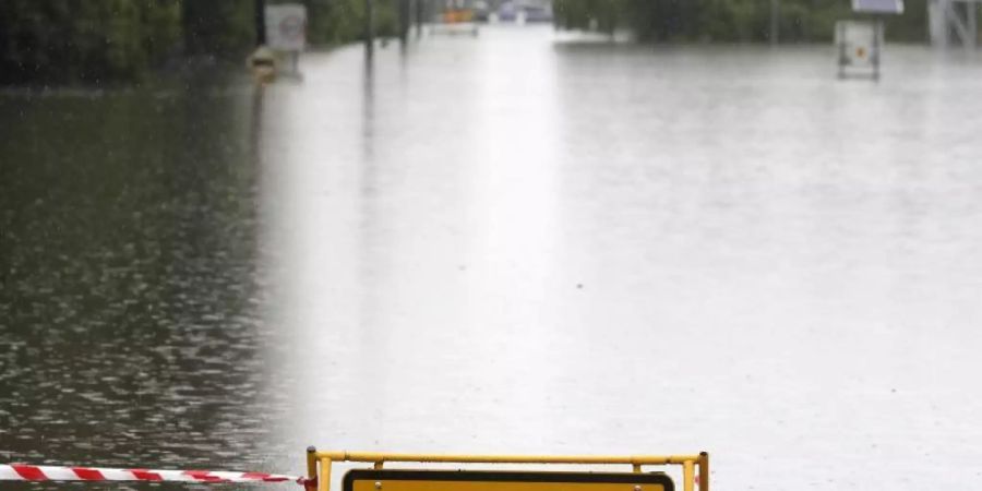 Ein Schild mit Warnhinweis auf einer überfluteten Strasse bei Windsor. Tagelanger Starkregen hat im Osten Australiens die schlimmsten Überschwemmungen seit Jahrzehnten ausgelöst. Foto: Rick Rycroft/AP/dpa