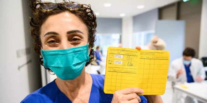 Eine deutsche Krankenschwester zeigt ihren Impfpass. Coronavirus Impfpass