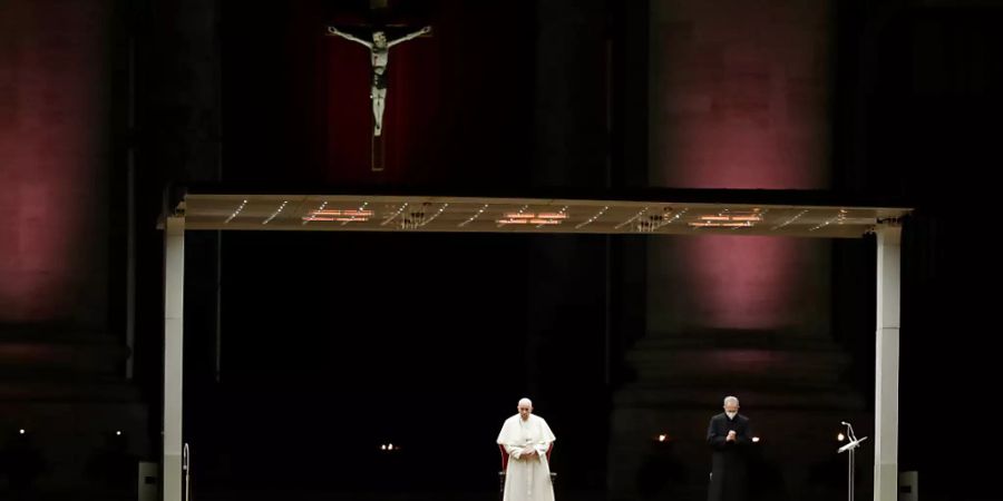 Papst Franziskus steht für den wichtigen Programmpunkt am Karfreitag, den Kreuzweg, auf dem leeren Platz vor dem Petersdom. Foto: Andrew Medichini/AP/dpa