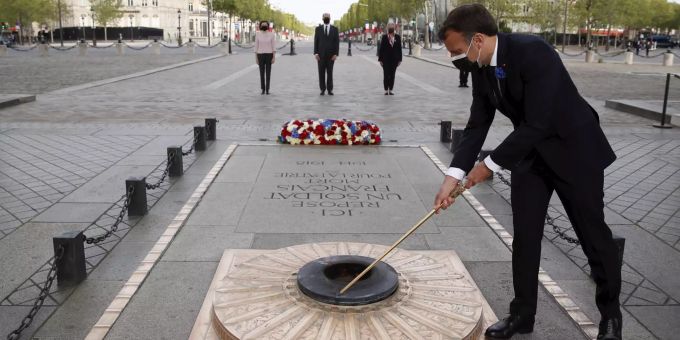 Frankreichs Präsident Emmanuel Macron erleuchtet die Flamme am Grabmal des Unbekannten Soldaten unter dem Arc de Triopmphe in Paris. emmanuel macron