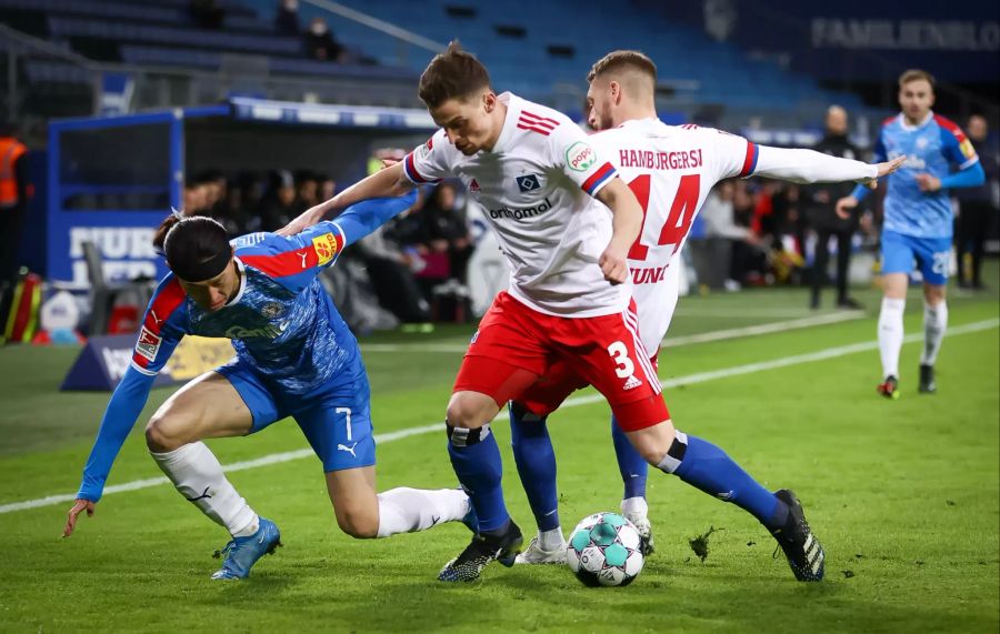 Jae-sung Lee (l.) von Holstein Kiel kämpft mit Hamburgs Moritz Heyer (r.) um den Ball.