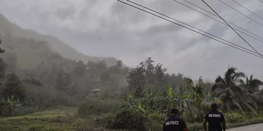 Polizisten patrouillieren nach dem Ausbruch des Vulkans La Soufrière auf einer aschebedeckten Strasse, um Menschen davon abzuhalten, sich dem aktiven Vulkan zu nähern. Foto: Orvil Samuel/AP/dpa