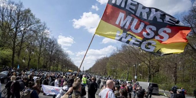 «Merkel muss weg» steht auf der Flagge eines Demonstranten beim Protest gegen die Änderung des Infektionsschutzgesetzes in Berlin am 21. April (Symbol). Foto: Fabian Sommer/dpa «Merkel muss weg» steht auf der Flagge eines Demonstranten beim Protest gegen die Änderung des Infektionsschutzgesetzes in Berlin am 21. April (Symbol). Foto: Fabian Sommer/dpa