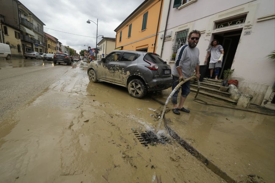 Ein Mann entfernt das Wasser aus seinem überfluteten Haus in Castel Bolognese, Italien, Donnerstag, 18. Mai 2023.