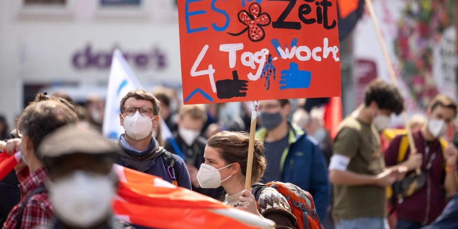 Eine Demonstrantin fordert bei einer DGB-Kundgebung zum 1. Mai in Erfurt die Vier-Tage-Woche.