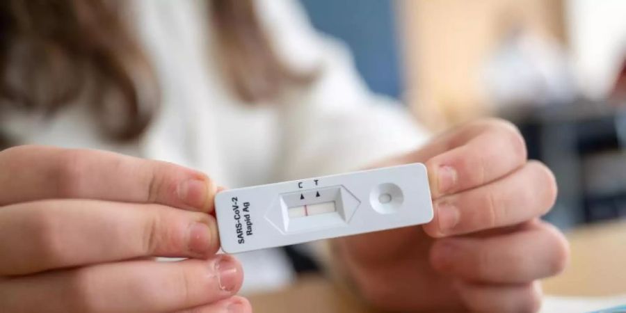 Gesund: Ein Schülerin zeigt in einer Klasse ihren negativen Corona-Schnelltest. Foto: Sebastian Gollnow/dpa