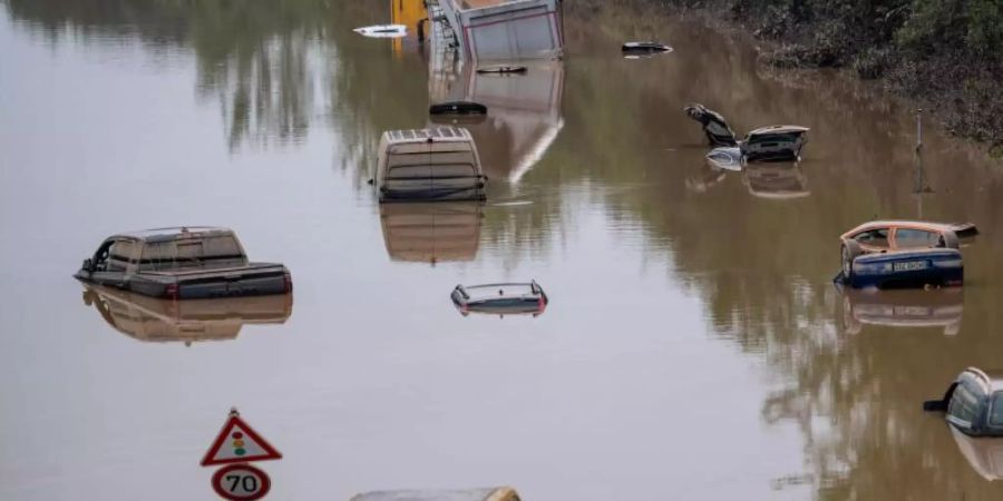 Autos stehen auf der überfluteten Bundesstrasse 265 in Erftstadt im Wasser. Foto: Marius Becker/dpa