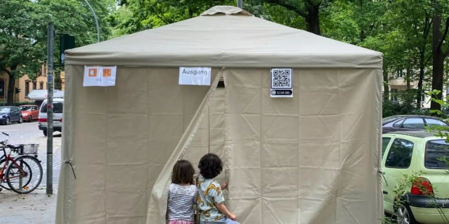 Kinder verfolgen die Impfung ihrer Eltern in einem Zelt in Berlin